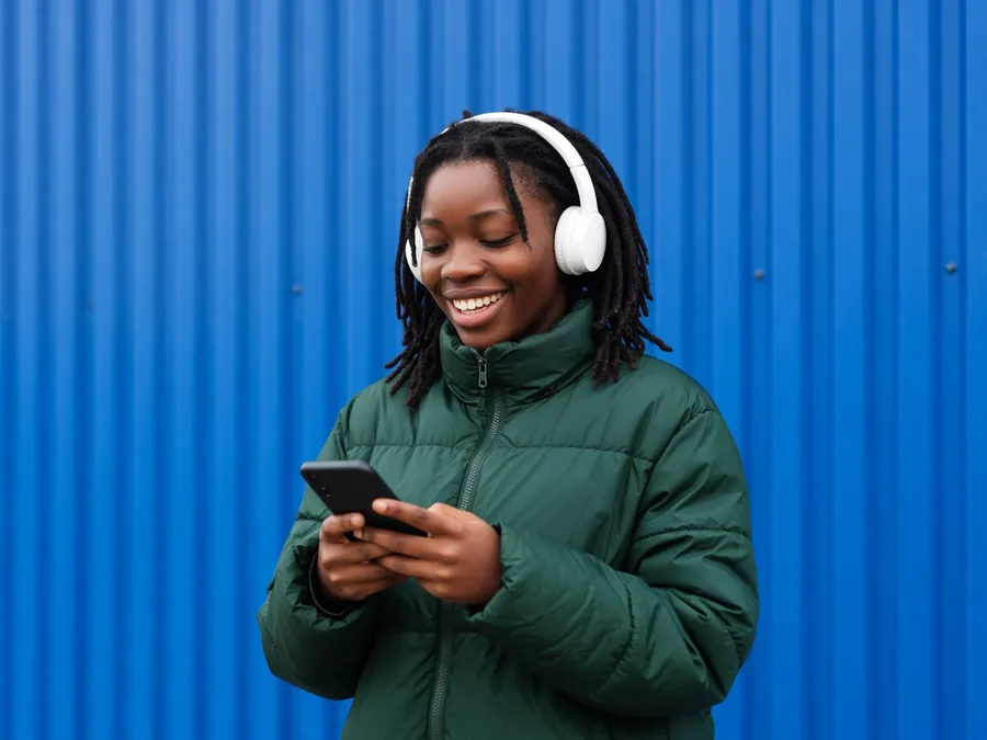 Woman with headphones typing a message on her phone